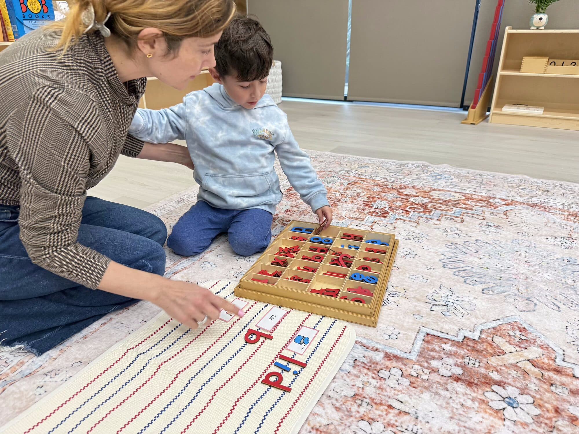 Teacher and child working with Montessori materials